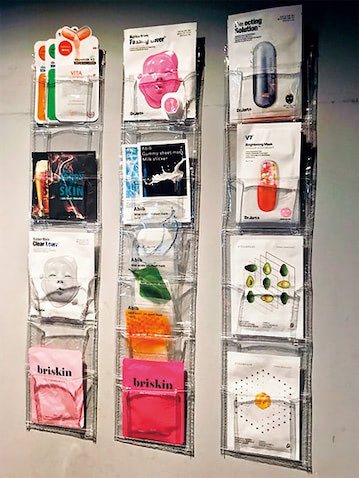 フェイスパックを絵画のように壁掛け：  「韓国のフェイスパックのかわいいパッケージデザインを生かし、セリアのウォールポケットで壁面収納。お店にいる感覚で眺めながら選べる。減りぐあいもひと目でわかるので便利です」（インフルエンサー／yaaamimiさん）