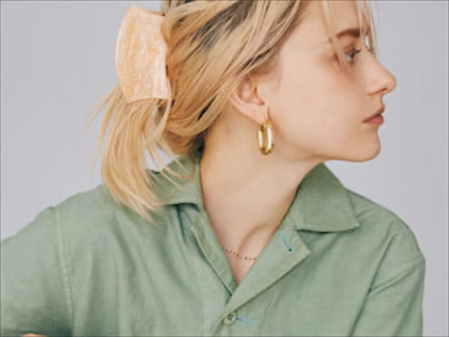 ヘアクリップは「抜けのある色・使い方」で： カーキのオールインワンに、女らしさを効かせるという意図で選ばれたヘアクリップ。コロンとした形で存在感があるため、抜けがあったほうがよいと考えました。おだんごヘアのトップのように目立つ位置につけるのではなく、振り向きざまにちらっと一部が見えるくらいに。毛流れは整えすぎず、おくれ毛もそのままにして、力の抜けた仕上がりをめざしました（扇本さん）。