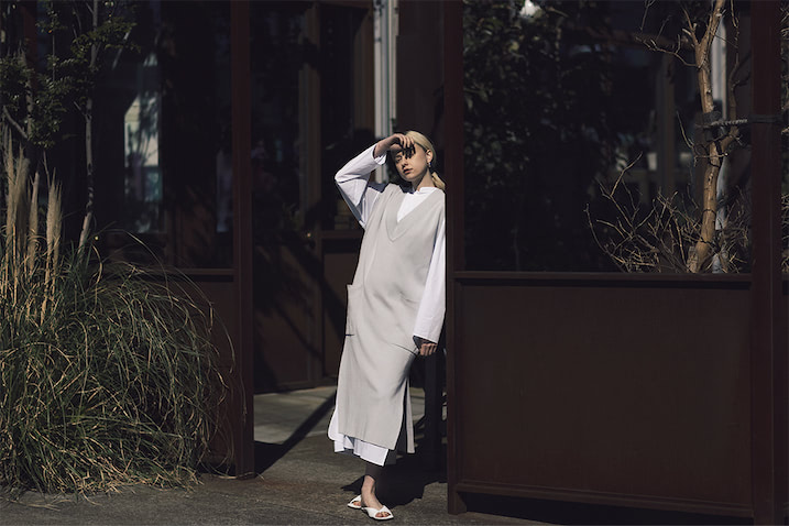 Ｖネックスリットロングベスト 24,200円／ADAWAS（ショールーム セッション）　ロングシャツワンピース 39,600円／blurhms（ワンダリズム）　ピアス 14,740円／PAZ COLLECTIVE（ZUTTOHOLIC）　白サンダル 30,800円／ピッピシック（RHC ロンハーマン）
