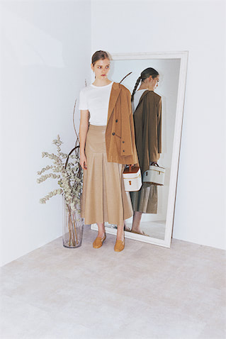 ベージュフェイクレザーフレアスカート 8,250円／STYLEMIXER（バロックジャパンリミテッド）　白Tシャツ 2,750円／PETIT BATEAU（プチバトー・カスタマーセンター）　肩にかけたベージュジャケット 53,900円／FLORENT　ゴールドピアス 8,360円／chibi jewels（chibi jewels JAPAN）　バニティバッグ 121,000円／L/UNIFORM（リュニフォーム トウキョウ）　ベージュローファー 15,290円／A de Vivre