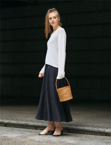 白ニット 16,500円／ロク、ブラウンラフィアバッグ 12,650円／バリワークスタット（ともにロク 渋谷キャットストリート）　スカート 28,600円／エッセン.ロートレアモン　ピアス 4,378円／CREDONA　別注サンダル 25,300円／STUDIOUS&times;HENRIENVARCO（ステュディオス ウィメンズ 表参道店）