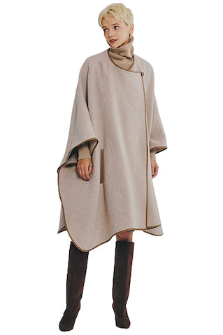 ベージュケープコート 59,400円／バビロン（エレメントルール カスタマーサービス）　ベージュニットワンピース 25,300円／LACOSTE（ラコステお客様センター）　ロングブーツ 90,200円／ネブローニ（デミルクス ビームス 新宿）　中に着たワンピースもロングだけから一転、ヒザ丈も多く出ている今シーズン。ケープも同様にロングブーツとの相性もいいヒザくらいのミドル丈が使いやすい。