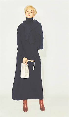 ロングブーツは黒のほかにもう１足、品よくはけて使いみちも多い「キャメル」を新投入。ネイビーニットワンピース 27,500円／ウィム ガゼット（ウィム ガゼット ルミネ新宿店）　肩にかけたニット 18,700円／スピック＆スパン（スピック＆スパン ルミネ有楽町店）　バッグ 16,830円／ノマディス（ガリャルダガランテ 表参道店）　リング（人さし指） 9,350円、リング（中指） 9,900円／ともにニナ・エ・ジュール（SHOWROOM 233）