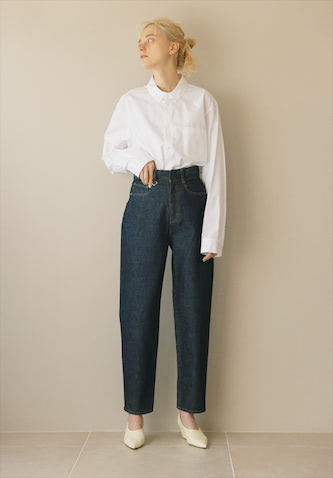 インディゴコクーンデニムパンツ 17,600円／MIESROHE　白シャツ 31,900円／ATON（ATON AOYAMA）　パンプス 35,200円／PIPPICHIC（ベイジュ）　●くびれから下を脚に見立ててくれるおへそ位置より上に設定した幅広ウエスト。ウエストのきゃしゃさが強まる、足首まで曲線を描くなだらかなシルエット。