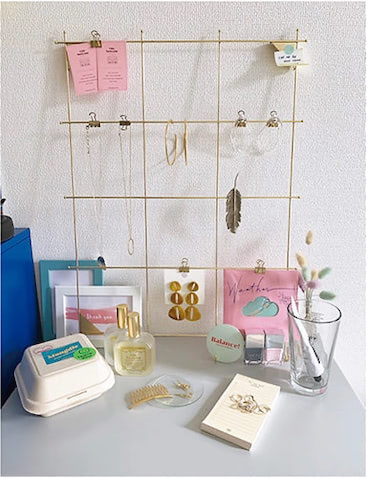 [クリップを使ったアクセサリーボード]壁に立てかけた格子状のワイヤーに、よく使うピアスやネックレスをクリップでとめています。大好きな韓国で買ったグラスやポストカードなども活用して、雑貨屋さんのようなイメージでレイアウトしてみました。 （鈴木早紀さん）