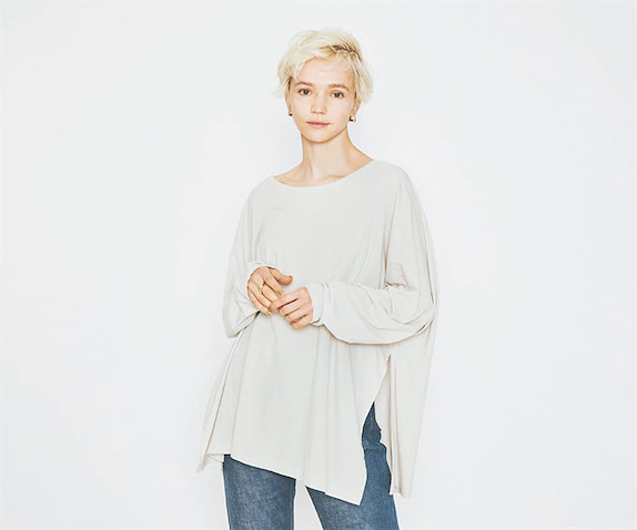 グレーTシャツ 11,000円／カオス（カオス表参道）　ピアス 13,090円／SOKO、リング 9,240円／FULL OF GRACE（ともにZUTTOHOLIC）　デニムパンツ／スタイリスト私物　そでのゆるさや、鎖骨がのぞくボートネックが女性らしい。