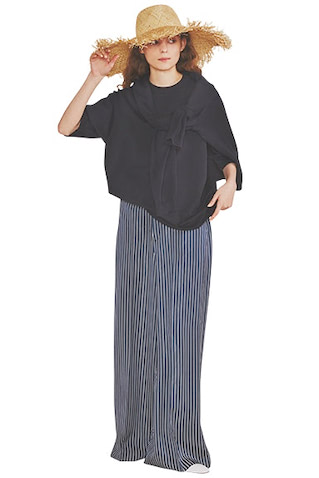 ネイビーTシャツ 31,900円、肩にかけたニット 39,600円／ともにATON（ATON AOYAMA）　ネイビー×白ストライプパンツ 33,000円／ENFOLD　ハット 9,900円／カテリーナ ベルティーニ（カレンソロジー 新宿）　パンプス 28,600円／ファビオ ルスコーニ（ファビオ ルスコーニ ルミネ有楽町店）　余白を残すリラックスした上下なら、まじめなネイビーでも夏素材を難なく受け入れられる。