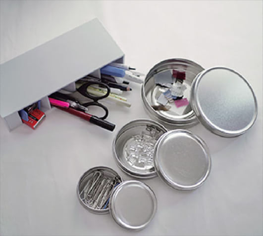 「小さい備品はシルバー缶に」 画びょうやクリップ、生地のサンプルスワッチは「Found MUJI」で購入したサイズ違いのブリキ缶で仕分けています。平たいふたなので重ねて置けるため、幅をとらないのがうれしいポイントです。