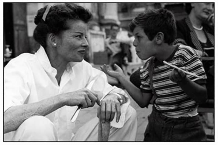 『旅情』（1955） ⚫︎パールの実力を証明する究極のシンプル： ベニスに観光で訪れた、オールド・ミスのジェーンを演じるキャサリン・ヘプバーン。劇中でも愛用していた一粒のパールでシャツを飾ったシンプルさ。無造作に着こなしたシャツにさえ品をもたらす、パールの威力を実感。