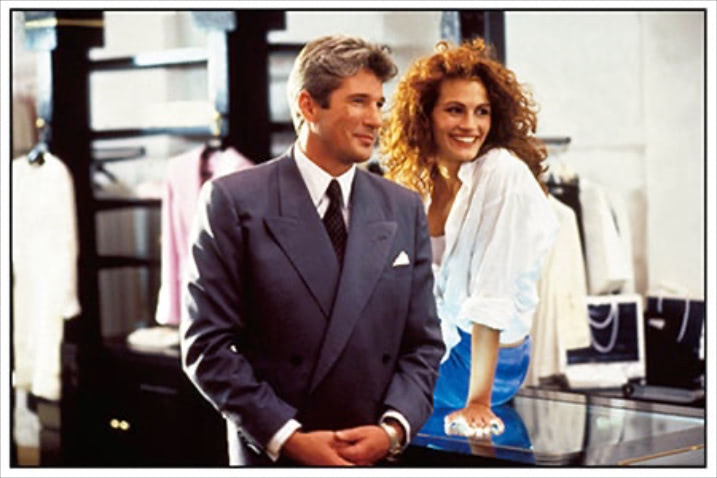 『プリティ・ウーマン』（1990） ⚫︎インナーを見せる前提の気だるいレイヤード： ジュリア・ロバーツ演じるビビアンらしい、キュートかつセンシュアルなシャツのレイヤード。ざっくりとデコルテの開いたインナーも、清潔感のある白シャツの効果でヘルシーなムードに転換。そでまくりで抜けを。