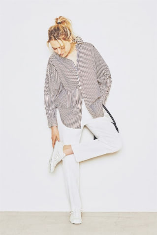 【PATTERN-1】スリムな白パンツに「とけ込ませる」：●白スニーカーははきまわし。ストライプシャツ 23,100円／ユニオンランチ（サザビーリーグ）　パンツ 25,300円／ロエフ（ユナイテッドアローズ 原宿本店）　バッグ 60,500円／MODERN WEAVING（ショールーム セッション）　■スニーカー自体細身のシルエットなら、スリムなパンツと縦のラインが引き締まる。色をそろえることでいっそう脚のラインがすらりと流れ、ビッグシャツをラフに着てもきちんと整う。
