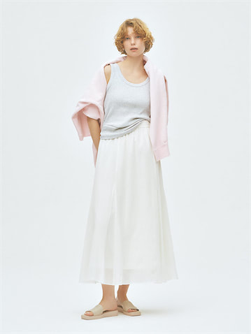 白＆グレーに華やぎを添える柔らかなスエット：● グレータンクトップ 1,000円／UNIQLO　肩にかけたピンクスエット 37,400円／ATON（ATON AOYAMA）　白フレアスカート 10,990円／UNFILO　サンダル 14,300円／Mollini（ジャック・オブ・オール・トレーズ プレスルーム）　スエットは「着る」から「かける」アイテムとして活用。