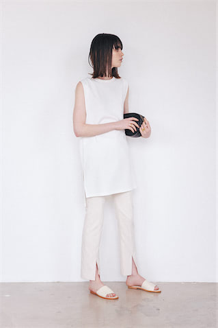 白チュニック 8,910円／uncrave STANDARD（uncrave）　オフ白パンツ 17,050円／ボッシュ　右手リング 36,300円、左手リング 29,700円／ともにモダン ウィービング（ザ ストア バイシー 代官山店）　バッグ 18,700円／Maison-Vincent（フラッパーズ）　サンダル 15,400円／SOL SANA（ジャック・オブ・オール・トレーズ プレスルーム）　スリット＆ノースリでスリムな見た目は保持。